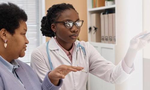 Primary care nurse practitioner with DNP reviewing treatment with patient